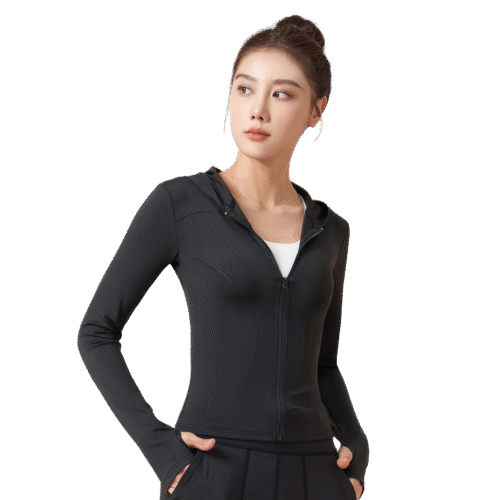 A woman wears a black zip-up hooded jacket with a V-neck collar, her hands casually resting in the pockets.