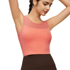a peachy pink sleeveless sports bra. The top features stylish mesh paneling across the upper chest and back, and a supportive racerback design.