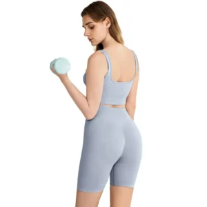 light blue square-neck sports bra and high-waisted workout shorts.