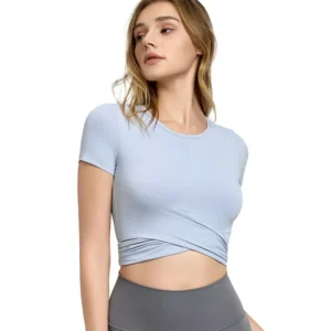 a light blue short-sleeve top. The top features a round neckline and a distinctive crossed and wrapped hem design that creates an asymmetrical, midriff-baring look.