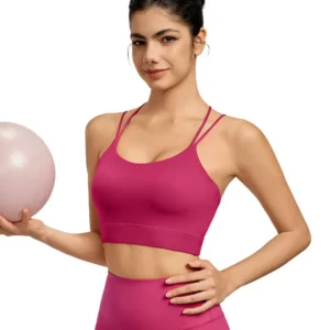 a fuchsia sports bra with a crisscross back design. The bra features thin, adjustable straps and a minimalist, sleeveless cut. The stretchy fabric provides a fitted look