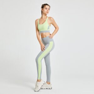 A sports bra with a combination of light green and gray, paired with gray high-waisted leggings featuring light green vertical stripes on the sides.