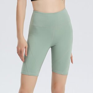 coral pink high-waisted athletic shorts. The shorts are made of stretchy, form-fitting sportswear fabric with diagonal light-toned stitching detail on the sides.