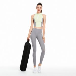 a sportswear set. The outfit consists of a sleeveless zip-up stand-collar athletic tank top in a color-block design of light yellowish-green and gray, paired with gray fitted workout leggings featuring white stripe details along the sides.