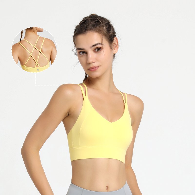 The sports bra features a deep V-neckline, thin straps, and a distinctive crisscross back strap design