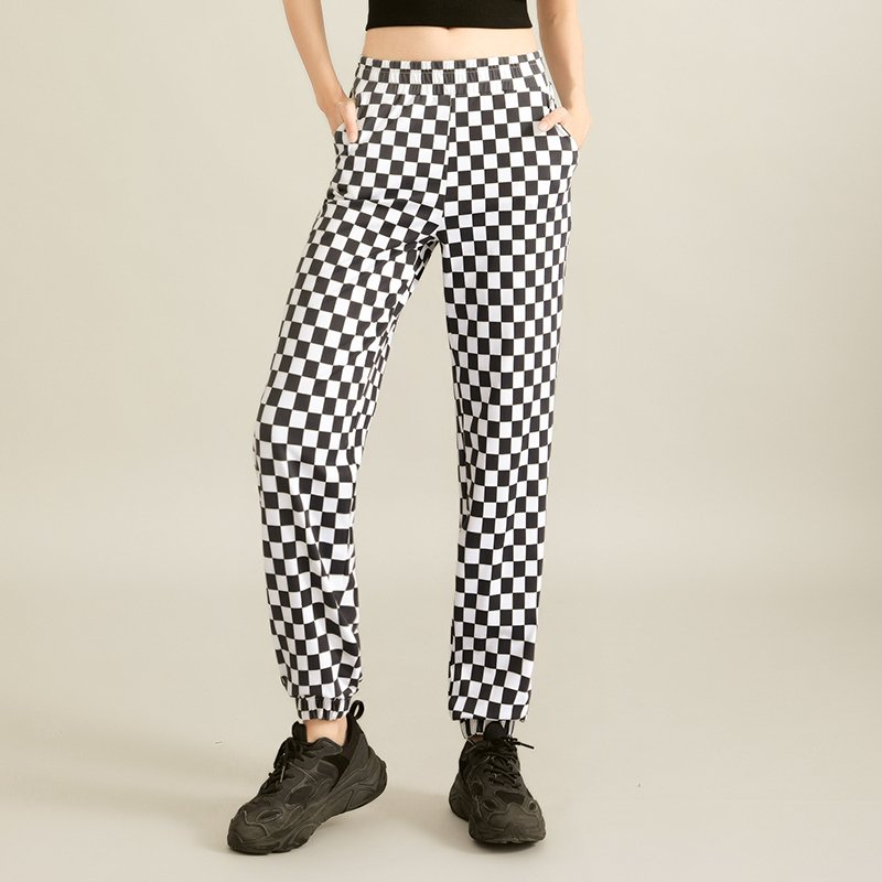a black crop top and high-waisted black-and-white checkered flared pants