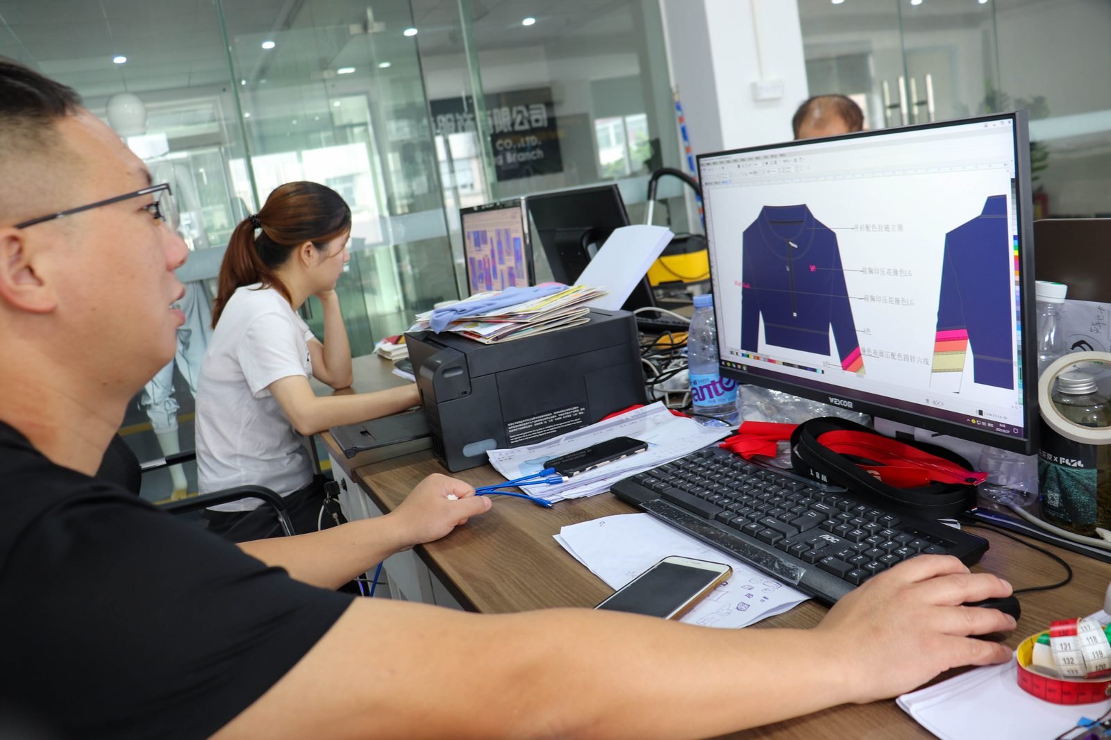 Design and merchandising team working on garment designs at the Enjoy Apparel office