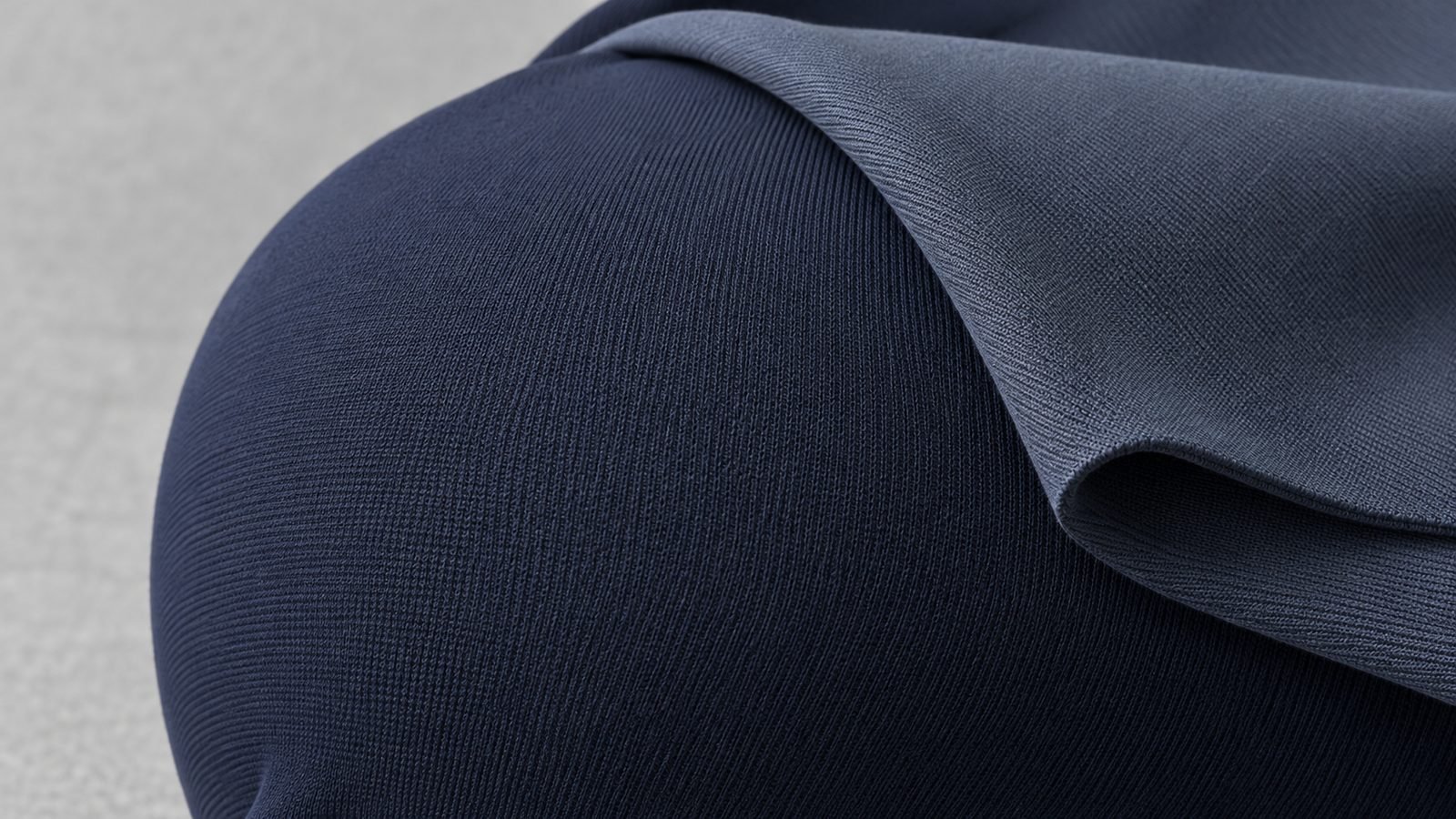 Close-up of dense matte four-way-stretch swimwear fabric showing its knit texture and opacity