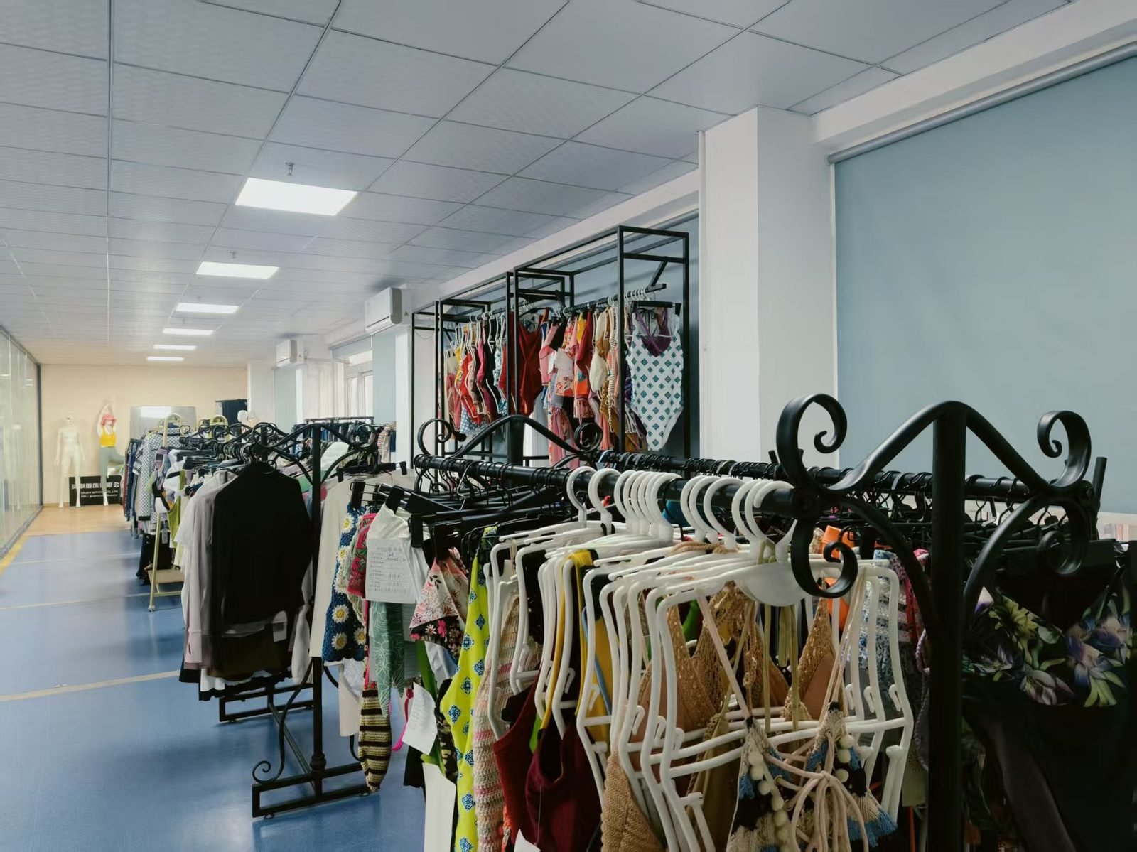 Sample room corridor with racks of swimwear styles produced for OEM clients