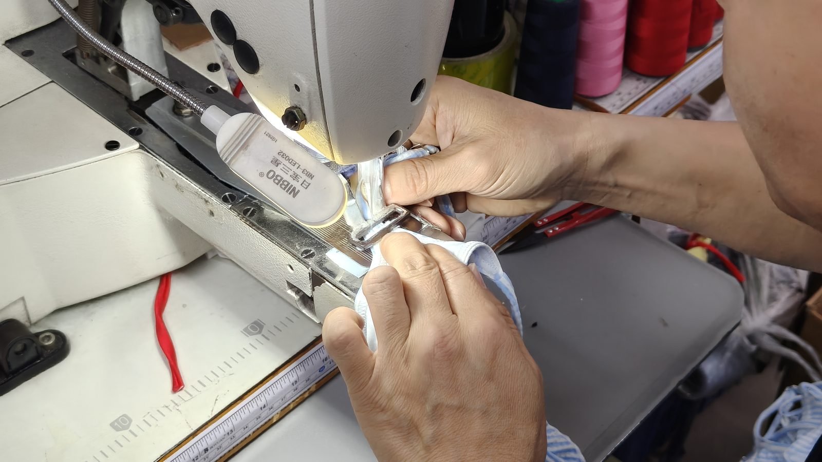 Sewer stitching swimwear fabric on an industrial sewing machine during production