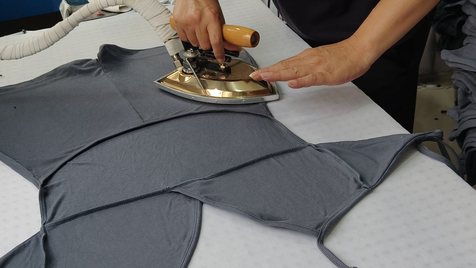 Steam-pressing a one-piece swimsuit during garment finishing