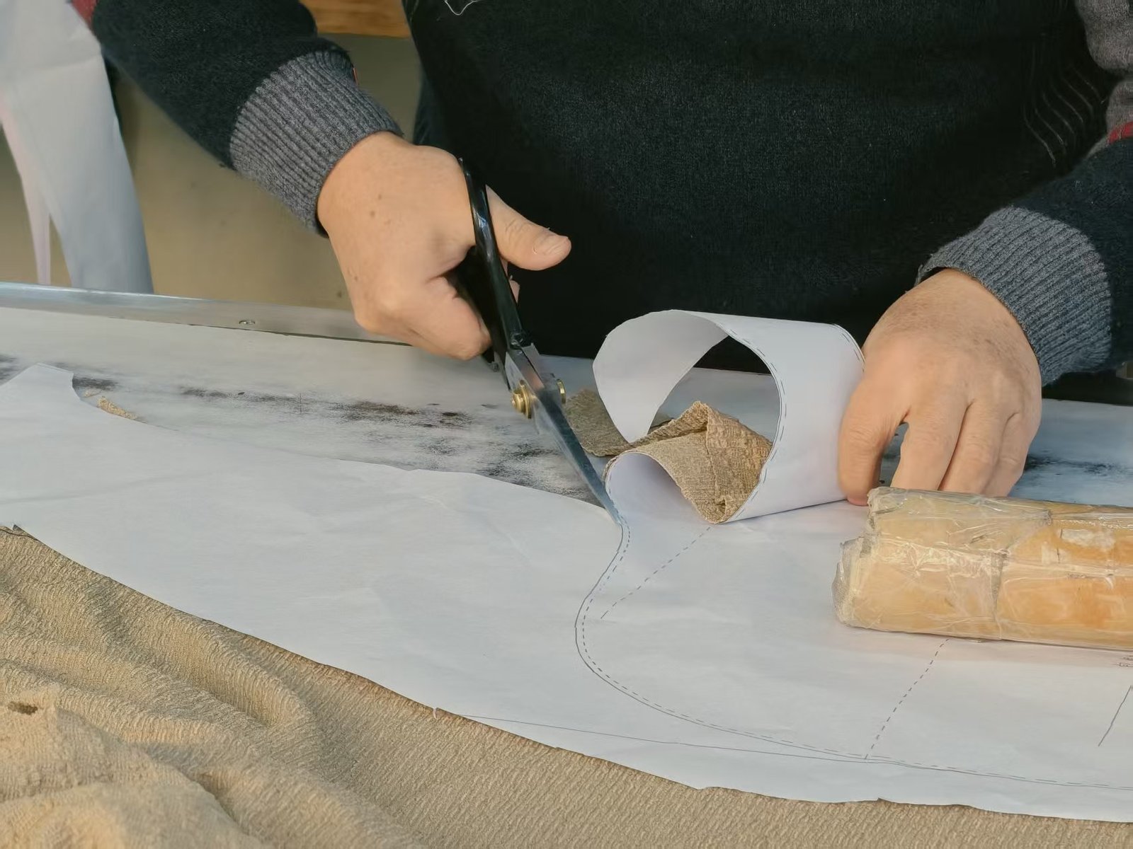 Cutting graded paper pattern pieces for a swimwear style before a size-set sample run is sewn